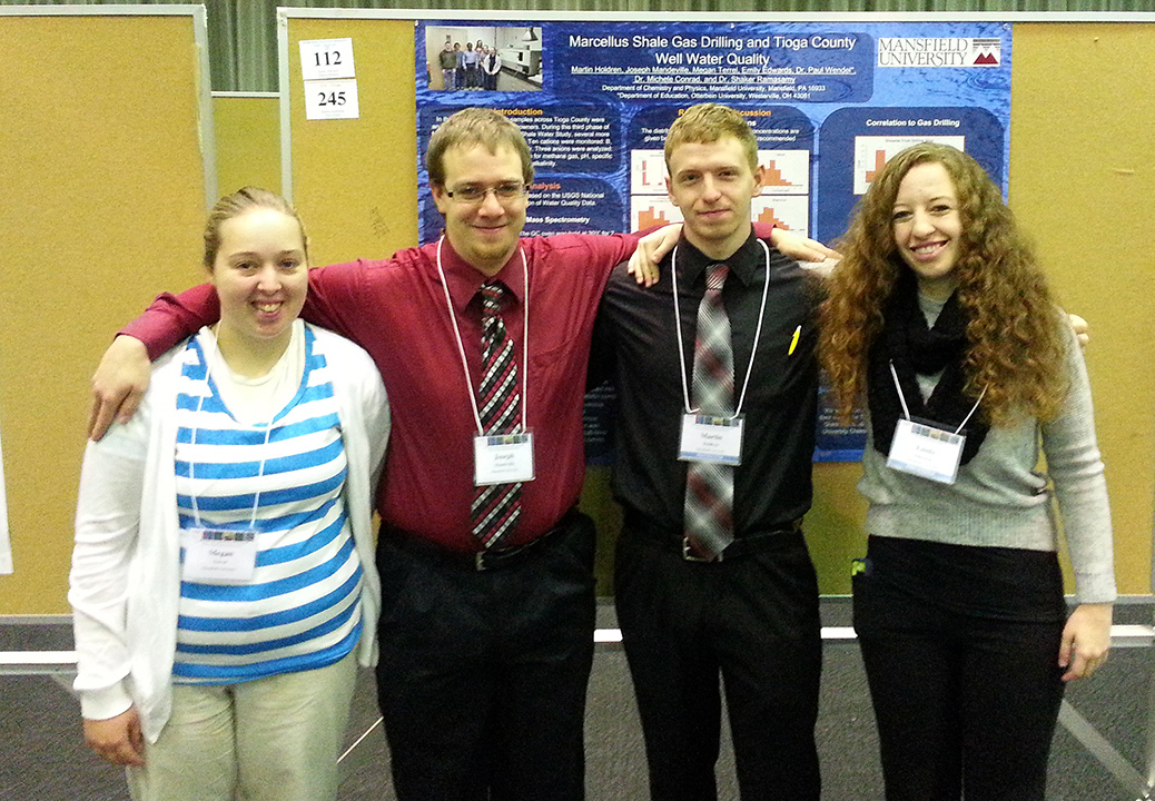 4 students standing in front of a research poster