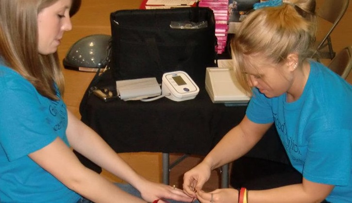 Student administering health screening on another student