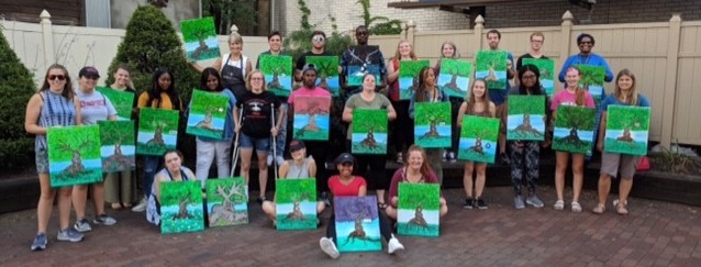 Group of students displaying their paintings